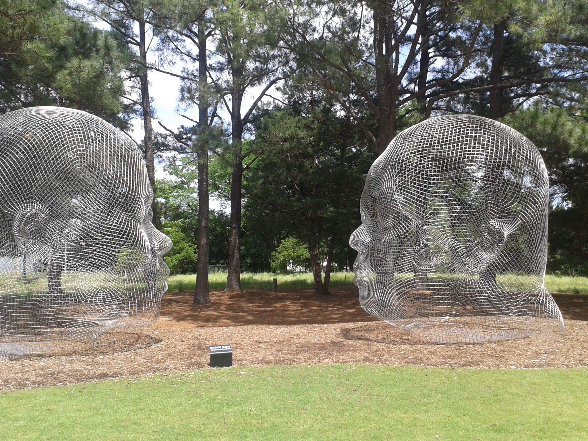 Kunstwerk: Drahtköpfe in einem Park