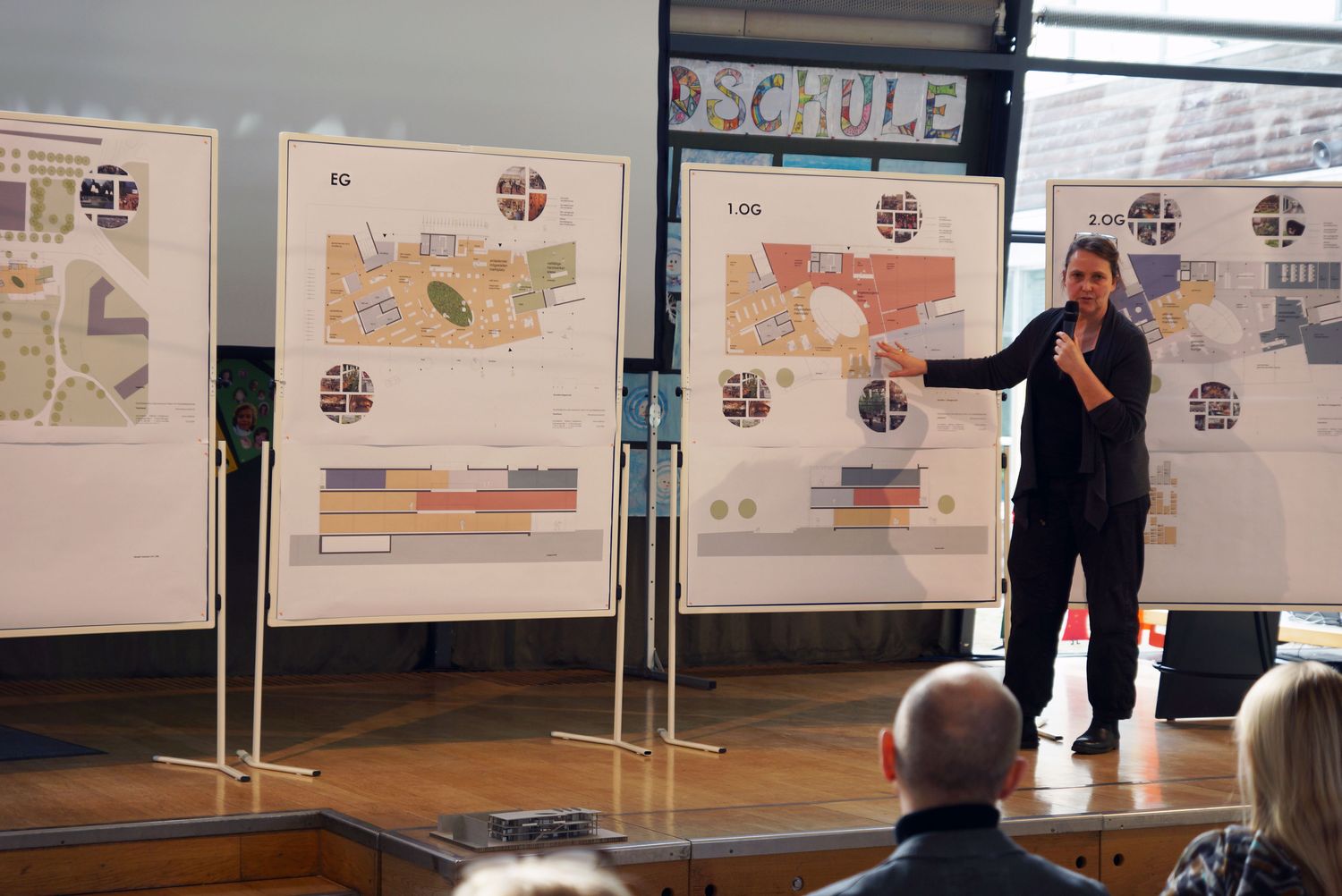 Architektin Barbara Rößner erläutert dem Plenum die Planskizzen an Stellwänden.